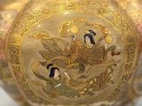 a gold vase with a picture of a woman on it
