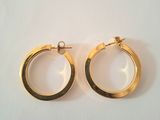 two pairs of gold hoop earrings on a white surface