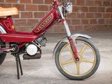 a red and gold motorcycle parked in front of a brick wall