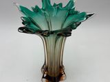 a glass vase with a green flower inside of it