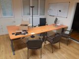 a desk with two chairs and a laptop on it
