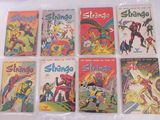 six bandes dessinées vintage différentes, dans des sachets en plastique, posées sur une surface blanche