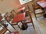 tables and chairs are lined up in a restaurant with a cat sitting on the floor
