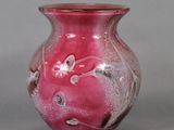 a pink vase that is sitting on a table