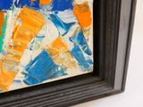 une image représentant un tableau aux tons orange et bleu, dans un cadre noir