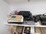 a desk with a laptop, a keyboard, a mouse, and other electronics on it