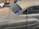an old car parked on the side of the street