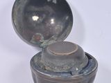 a small bowl with a lid on a white surface
