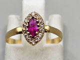 a yellow gold ring with a ruby stone and diamonds