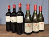 several bottles of wine are lined up on a wooden table