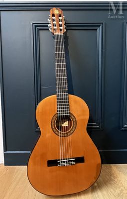 an acoustic guitar sitting on a wooden floor in front of a blue door