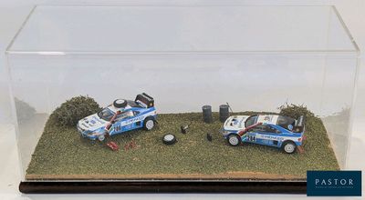 deux petites voitures dans une vitrine transparente posée sur une table
