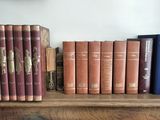many books that are on a shelf in a room