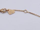 a close up of a gold bracelet with a heart on it