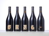 six bottles of wine lined up in a row on a table