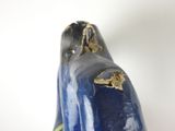 a blue vase with a gold decoration on the top of it