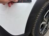 a person holding a sticker on the side of a car