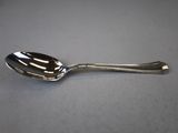 a silver spoon with a spoon handle on a table