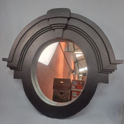 a round mirror on the wall with a reflection of a building in it