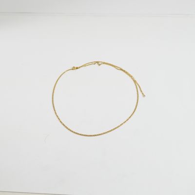 un bracelet en chaîne d'or à chaîne unique sur fond blanc