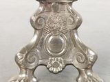 a silver candle holder with a flower on top of it
