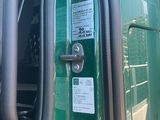 a close up of a door handle on a green truck