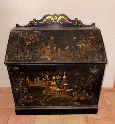 une boîte noire et dorée posée sur un sol carrelé