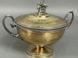 an antique silver and gold covered bowl with a horse on top