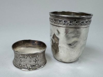 une coupe en argent à côté d'une autre coupe en argent sur une table