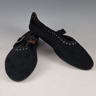 pair of black sued shoes with metal buckles on the toes