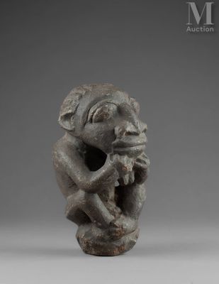 a small statue of a monkey holding a piece of wood