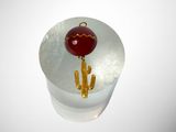 a glass ornament with a gold cactus and a red ornament hanging from it