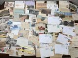 de nombreuses cartes postales anciennes posées sur une table, avec une chaise en arrière-plan