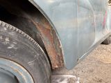 a cat that is sitting under the tire of a truck