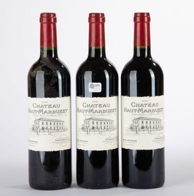 trois bouteilles de vin rouge posées l'une à côté de l'autre sur une surface blanche