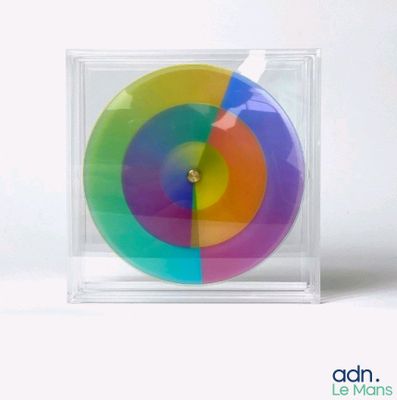 a multicolored object in a clear box on a white surface
