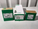 trois boîtes contenant du matériel électronique vert et blanc posées sur une table