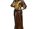 a bronze statue of a woman holding her hands on her chest