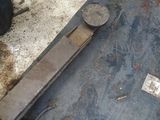 a piece of metal sitting on the ground next to a tire