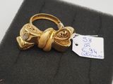un gros plan d'une bague en or ornée d'un nœud