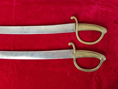 pair of two swords on a red cloth on a red surface