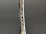 close up of a spoon and fork on a table with a spoon in the foreground