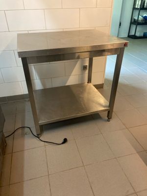 une table en acier inoxydable au milieu d'un sol carrelé