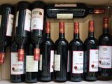 bottles of red wine in a cardboard box on a table