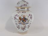 un petit vase avec un couvercle posé sur une table blanche