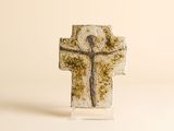une croix sur laquelle est représenté un homme, posée sur une table
