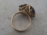a gold ring with a purple stone on it