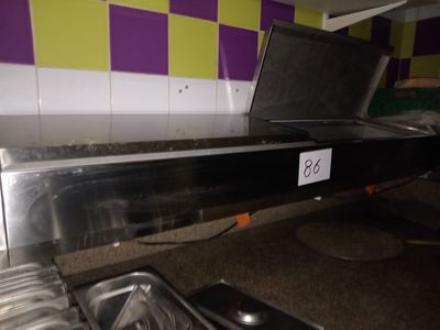 un mur recouvert de carreaux à carreaux violets et jaunes, sur lequel est posé un ordinateur portable