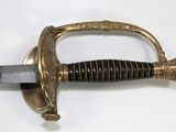 an old sword with a gold handle on a white surface