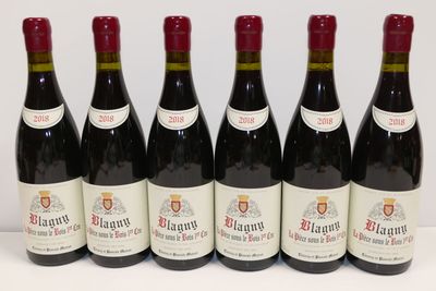 six bouteilles de vin rouge sont alignées sur une table